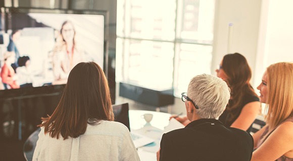 在大屏幕上观看网络研讨会的办公室职员