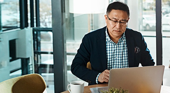 中年绅士在笔记本电脑屏幕上看书