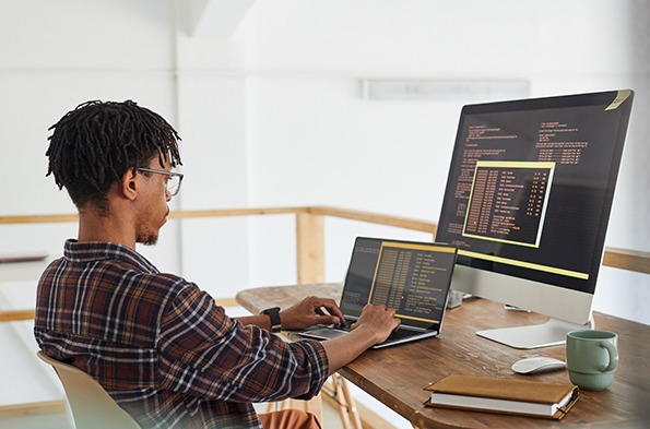 网络管理员在笔记本电脑和显示器前