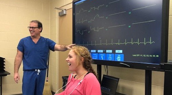 磨砂膏中的医学专家向孩子们介绍医疗监视器